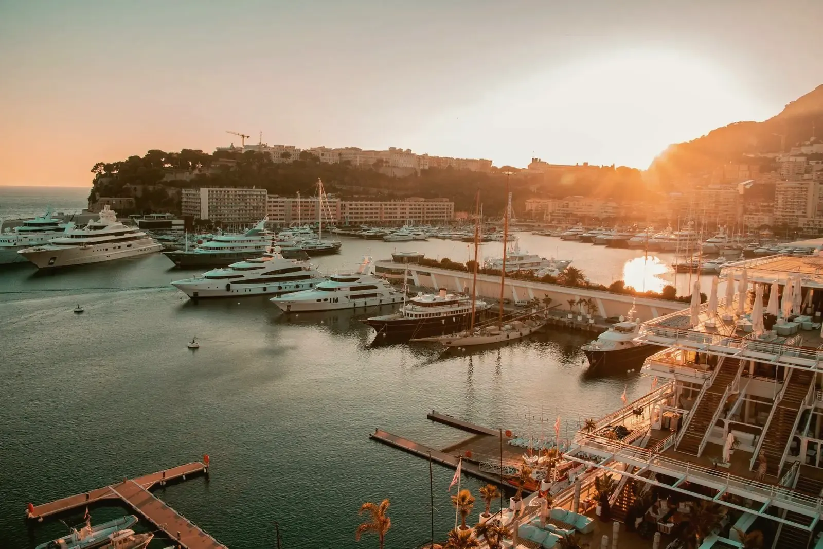 Puerto deportivo con yates a motor amarrados al atardecer, con la ciudad detrás