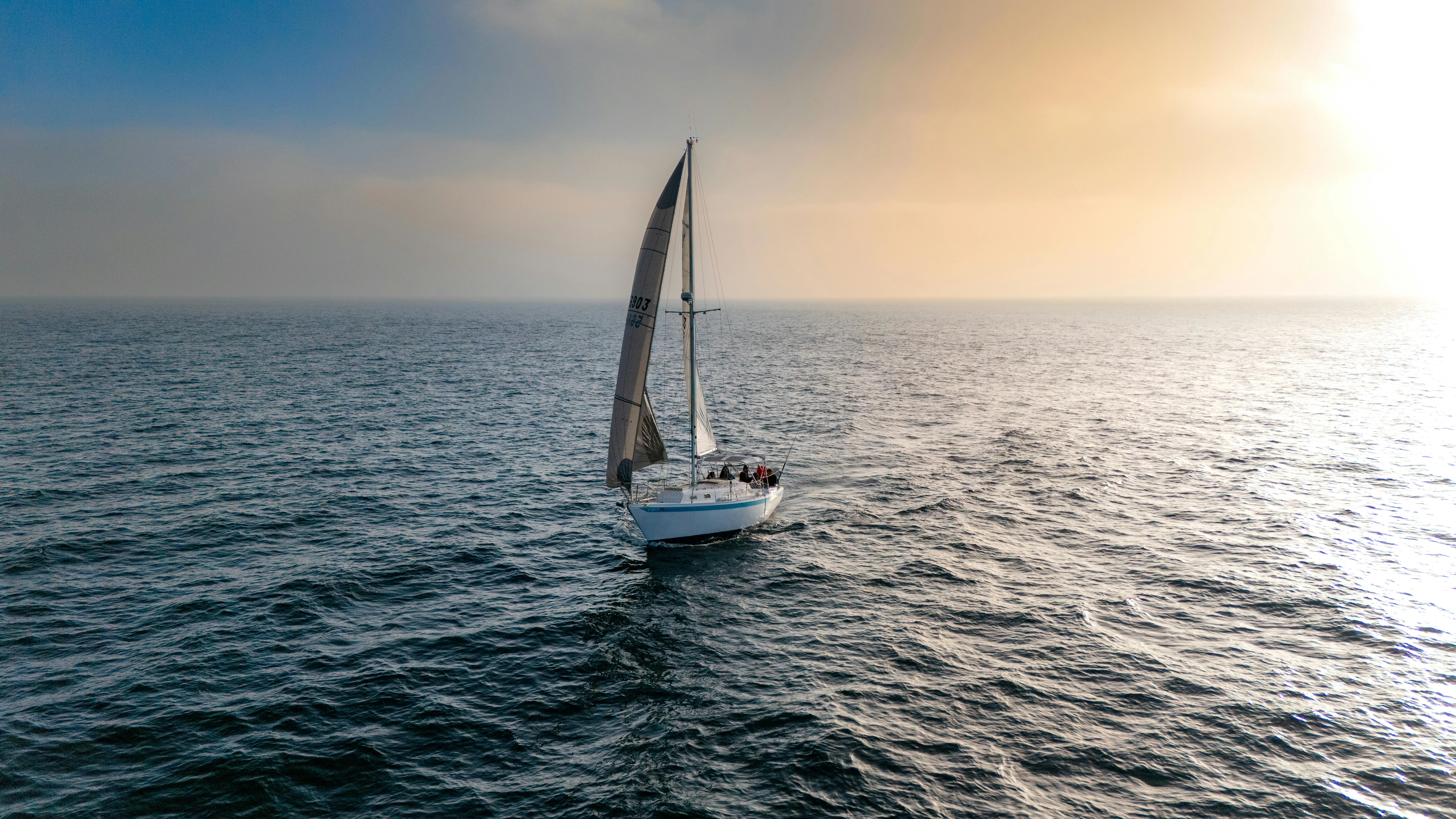Velero navegando en el océano al atardecer